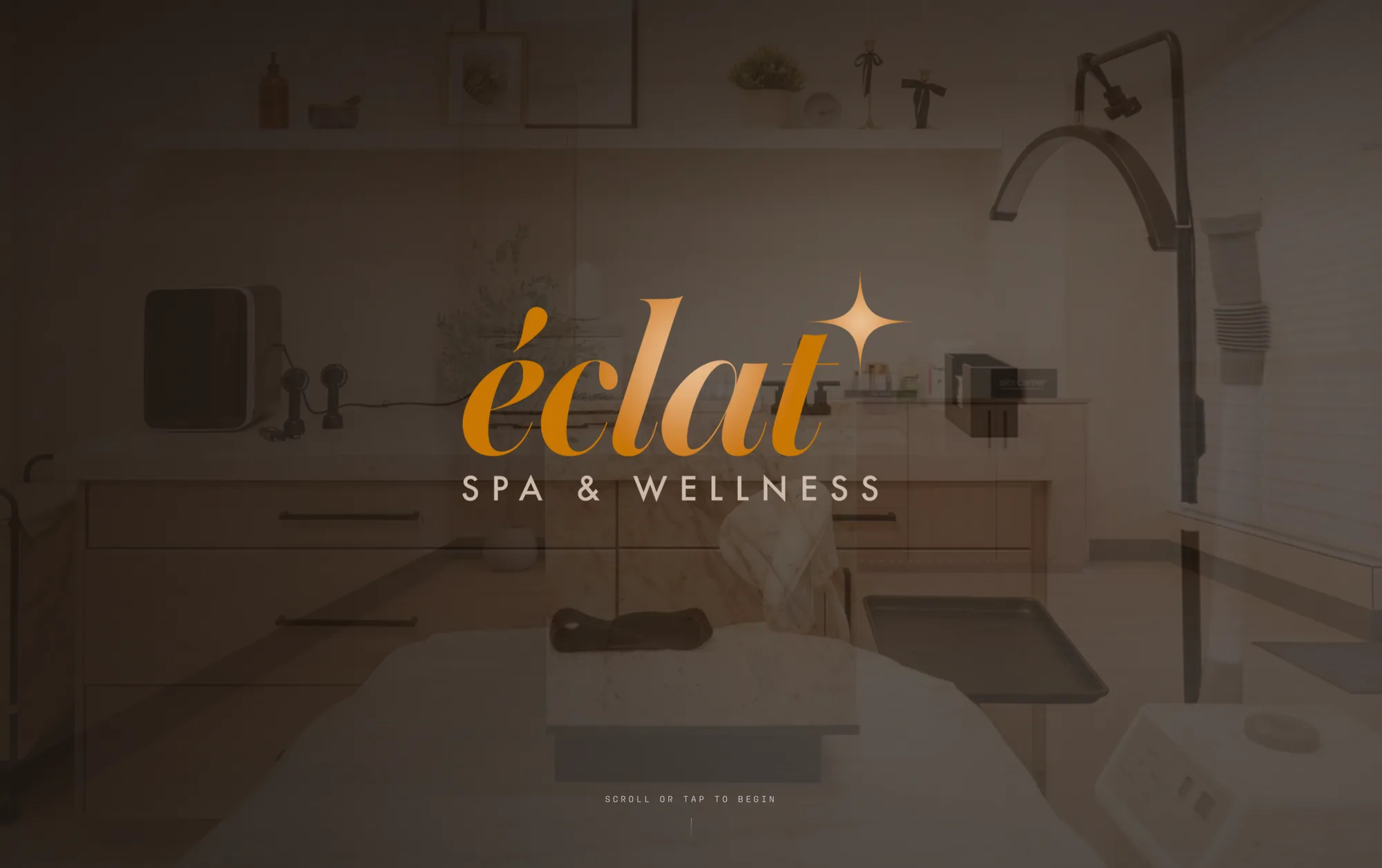 The Éclat Spa & Wellness homepage: the rose-gold éclat wordmark and its four-point star centered over a dimmed photograph of a real treatment room, above the line 'scroll or tap to begin'.